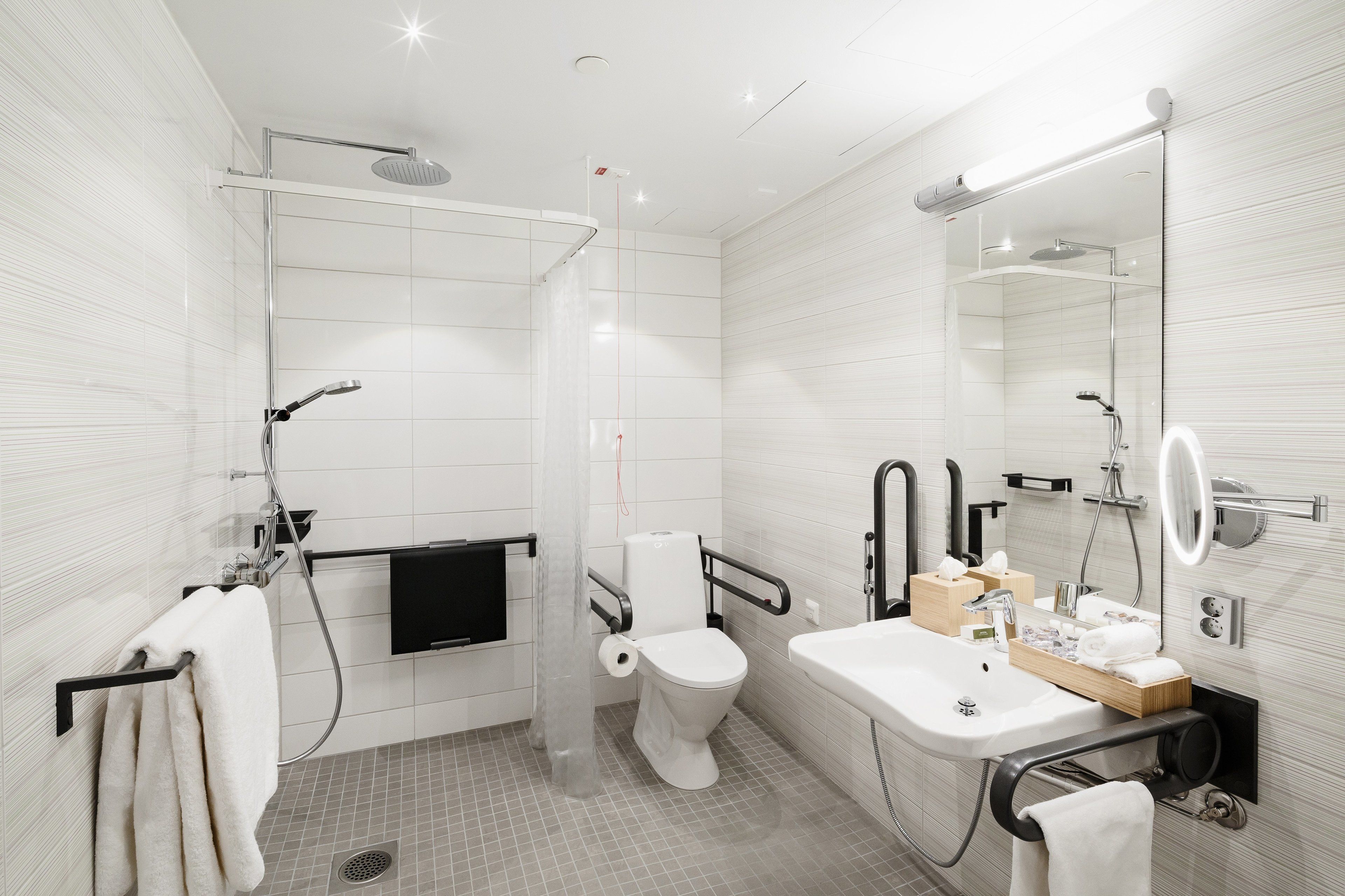 A modern bathroom with a shower, toilet, and sink.