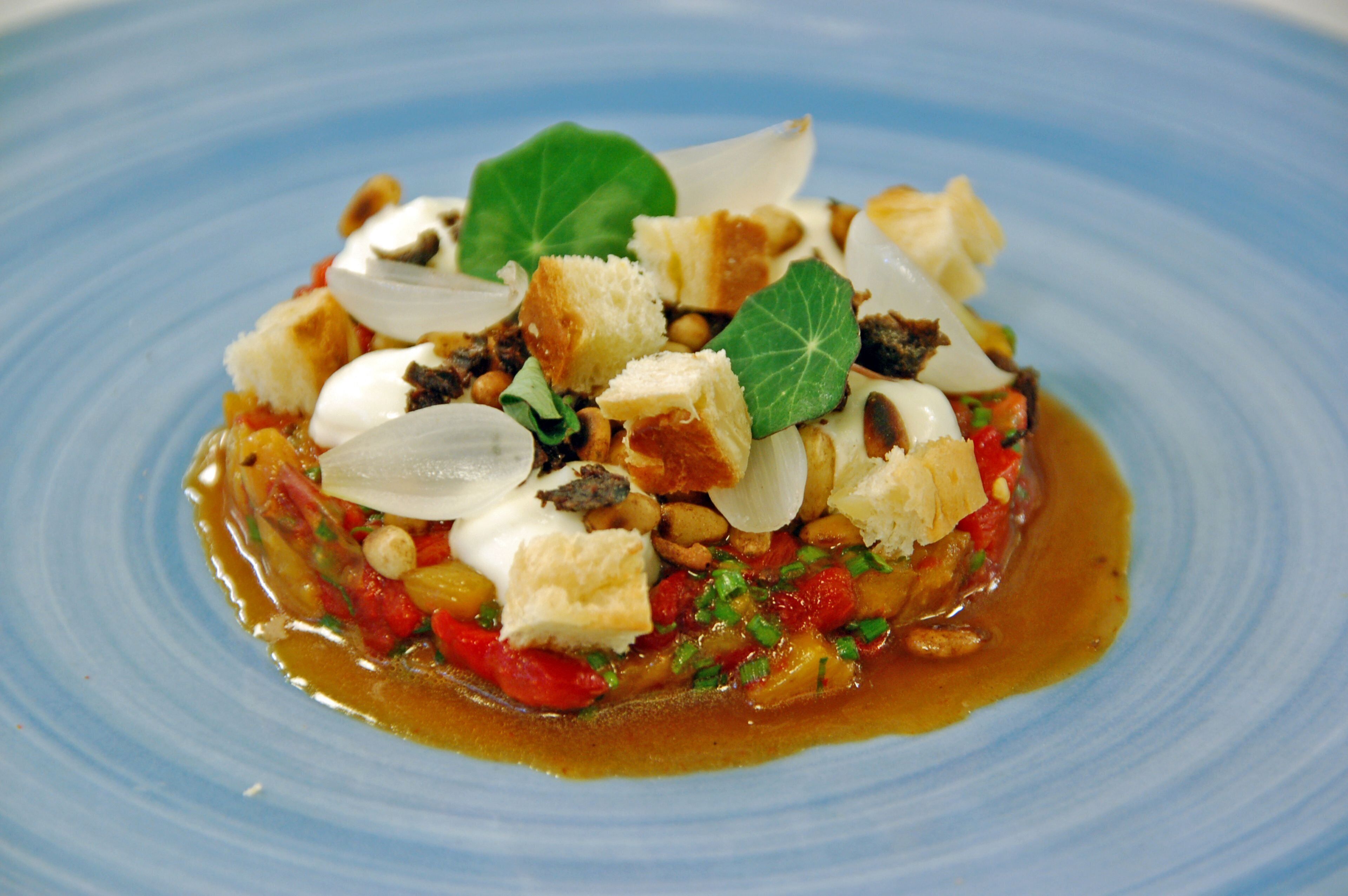 Un plato azul con diversos ingredientes y guarniciones.