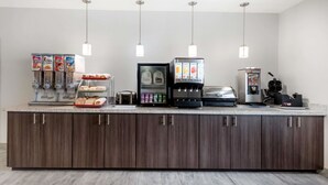 A self-service breakfast bar with cereal, milk, and coffee options.