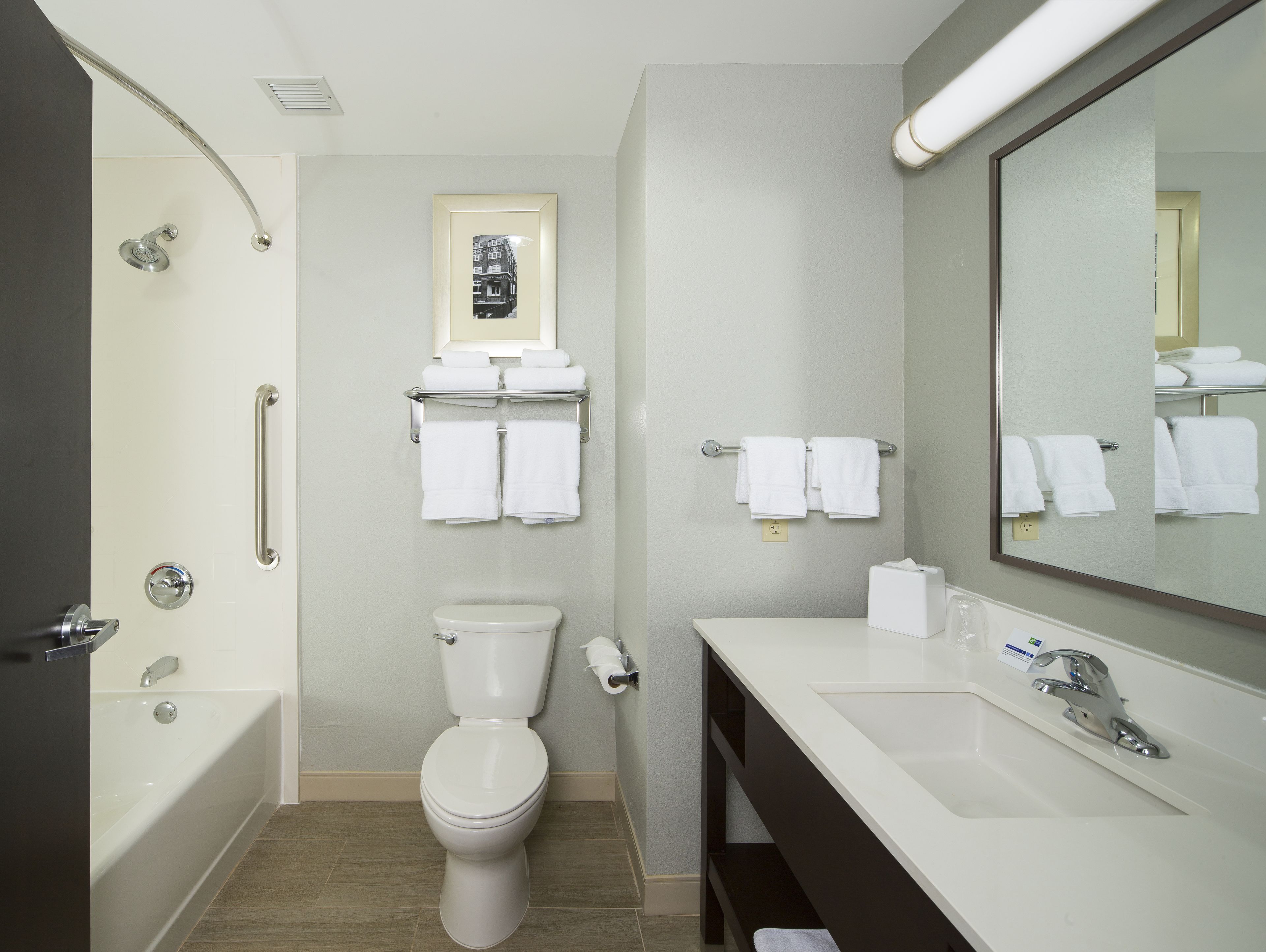 A modern bathroom with a bathtub, toilet, and sink.