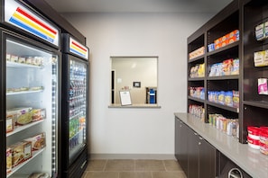 A clean, well-organized snack bar with refrigerated and shelf storage for beverages and snacks. - Holiday Inn Express & Suites Oklahoma City Dwtn - Bricktown by IHG (Oklahoma City)