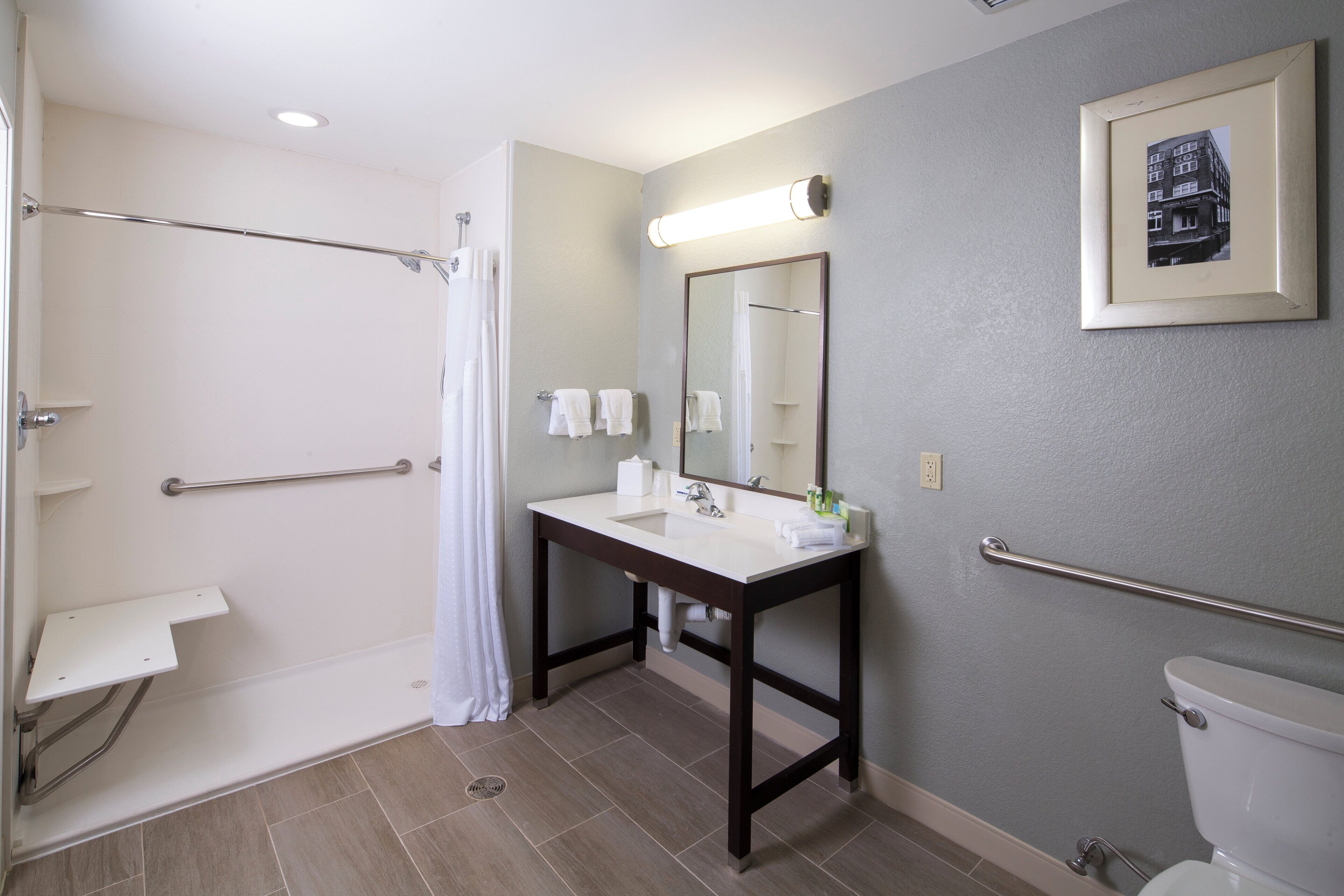 Une salle de bain équipée d’une douche, d’un lavabo, de toilettes et d’un miroir.