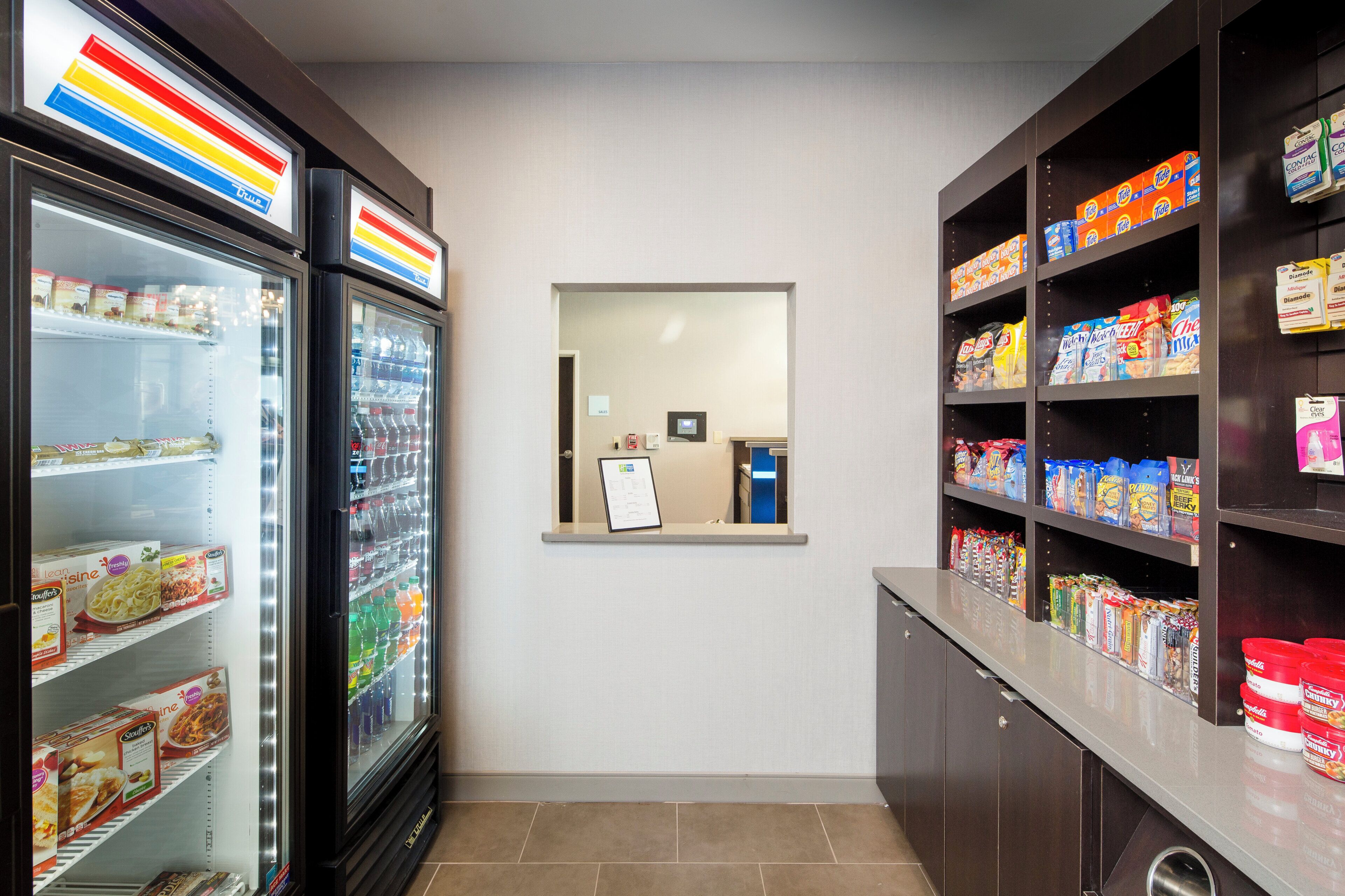 Un’area self-service con distributori automatici di bevande e scaffali pieni di snack e bevande.