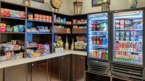 Une épicerie de proximité bien approvisionnée, avec des rayons remplis d’en-cas, de boissons et de produits emballés.