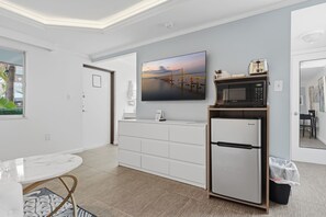 Eine moderne Küche mit weißen Schränken, einer eingebauten Mikrowelle und einem Kühlschrank.