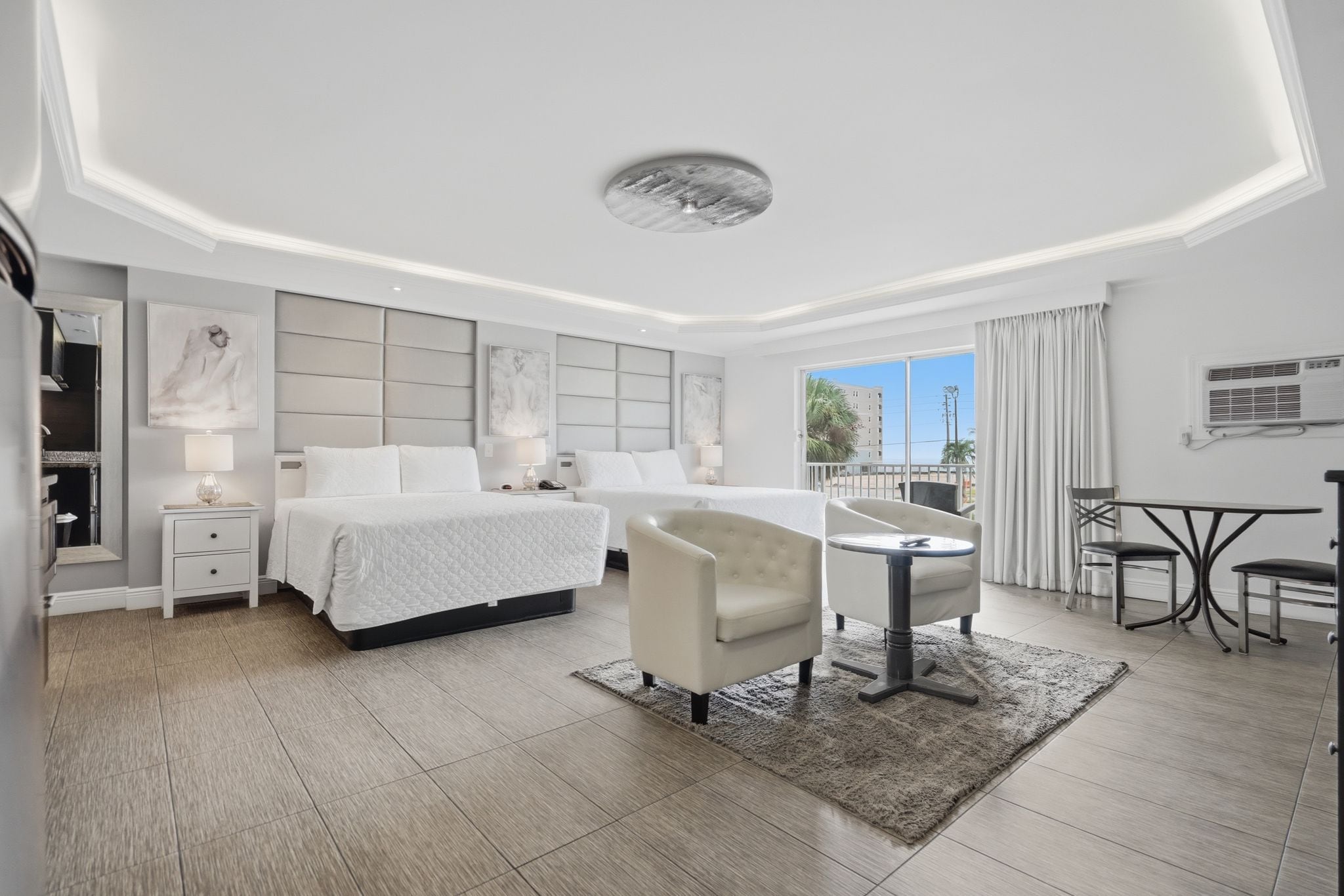 A modern hotel room with a large bed, a desk, and a chair.