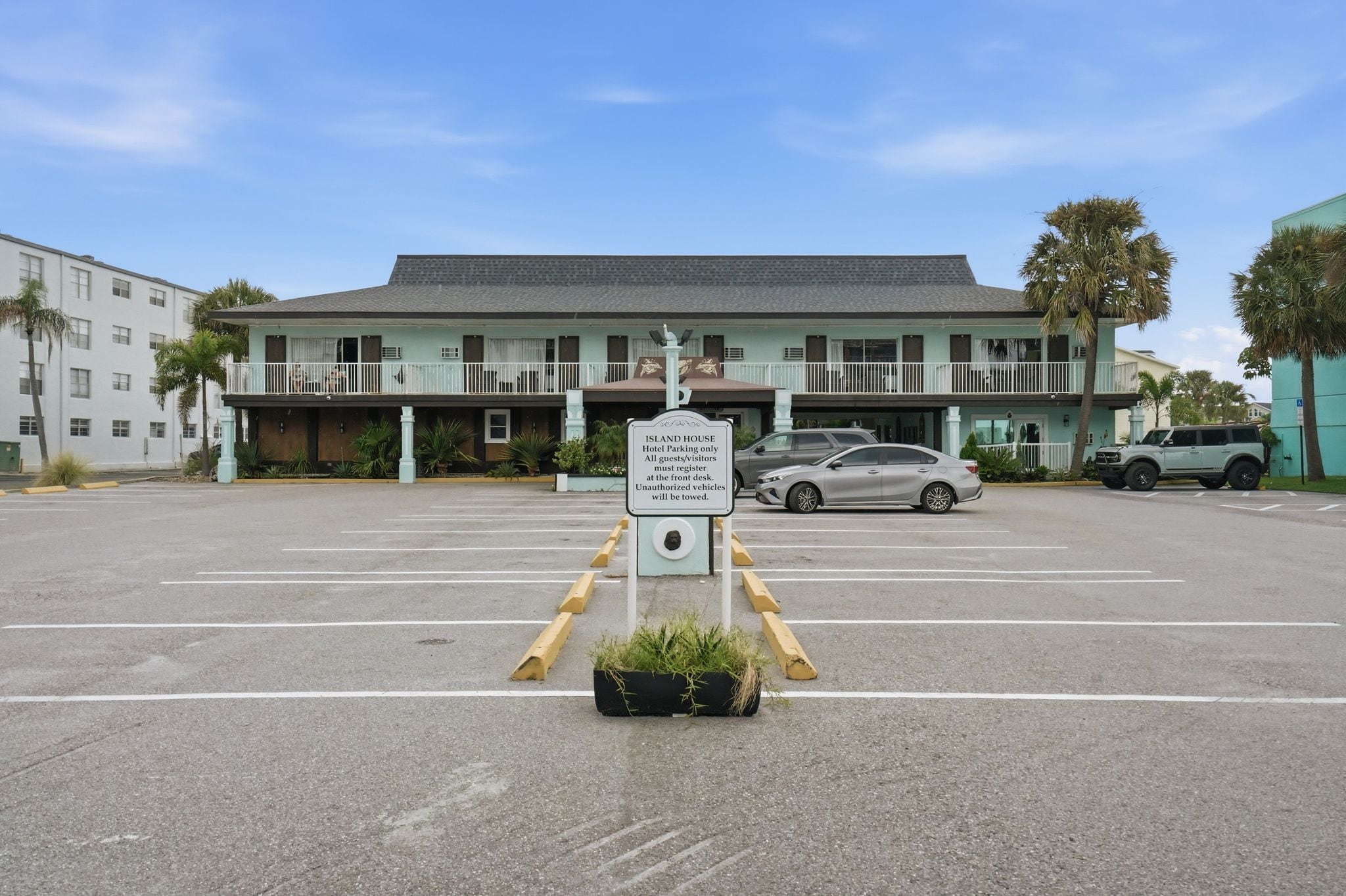 Un hôtel avec un panneau indiquant l’emplacement du parking réservé aux clients et les modalités d’enregistrement.