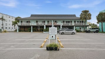 Un hôtel avec un panneau indiquant l’emplacement du parking réservé aux clients et les modalités d’enregistrement.