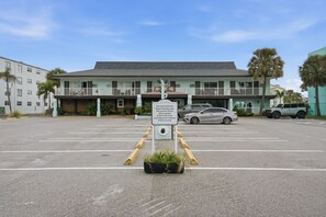 Un hôtel avec un panneau indiquant l’emplacement du parking réservé aux clients et les modalités d’enregistrement.