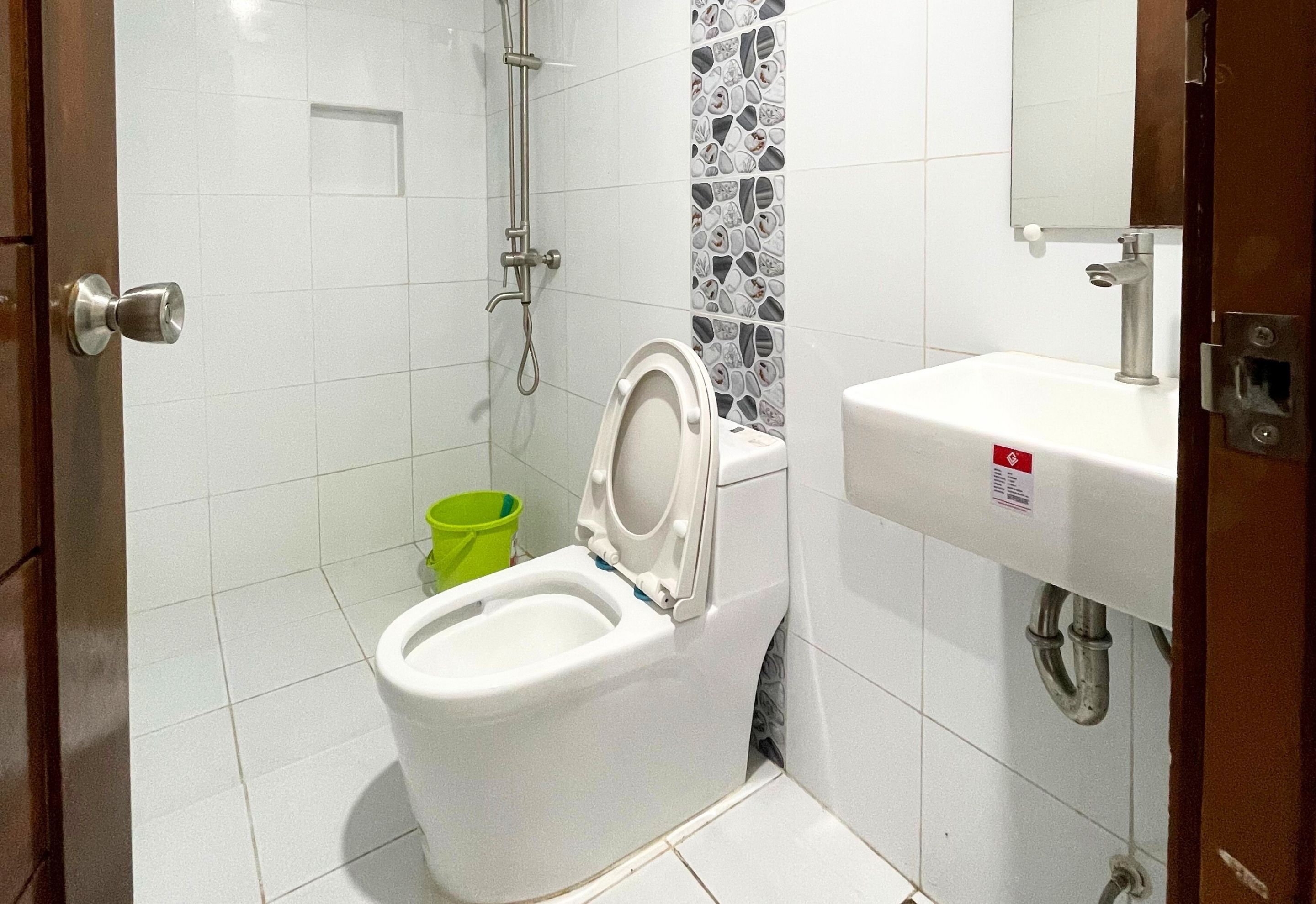 Un baño con inodoro, lavabo y zona de ducha.