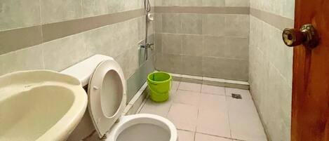 A small bathroom with a toilet, sink, and shower.