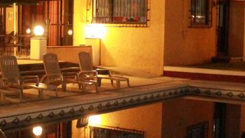 Alberca al aire libre y camastros