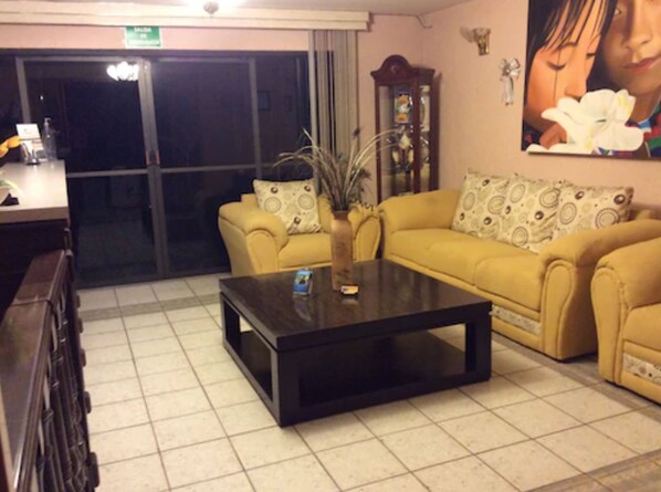 A living room with a sofa set, a coffee table, and a decorative vase.