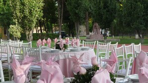A table set for a formal event with white chairs and pink napkins. - Hotel Finca Las Hortensias (Tepotzotlán)