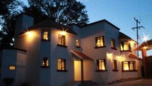 A multi-story building with multiple windows, a staircase, and a paved entrance area. - Hotel Finca Las Hortensias (Tepotzotlán)