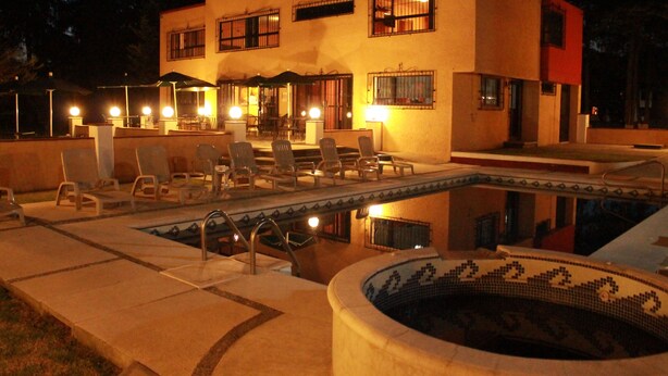 A building with a pool, outdoor seating, and a hot tub. - Hotel Finca Las Hortensias (Tepotzotlán)
