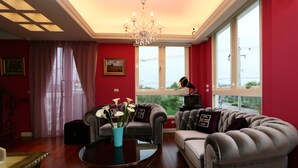 A living room with a chandelier, red walls, and a large window. - Aleex Villa (Yuanshan)