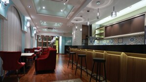 A restaurant with red chairs, a bar area, and a tiled backsplash. - Aleex Villa (Yuanshan)