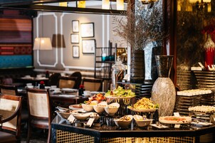 A buffet setup with various dishes and a decorative vase.