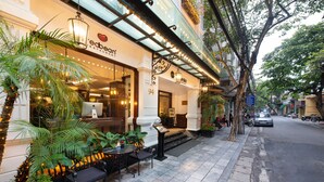 Un área con mesas y sillas para sentarse al aire libre, una palmera y un edificio con un letrero que dice "ebetan restaurant".