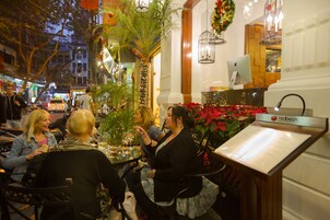 Een restaurantinterieur met tafels, stoelen en een menukaartstandaard.