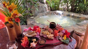 A tropical setting with a stone hot tub surrounded by lush greenery. -  CHALET TROPICAL Hotel & Pool Bar Restaurant (Las Galeras)