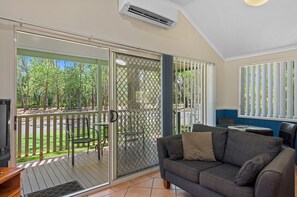 Villa Deluxe, varias camas | Área de sala de estar | Televisión 