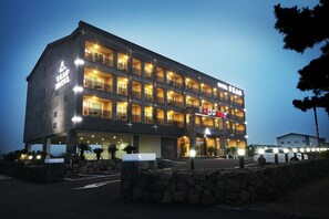 Vista frontal de la propiedad por la tarde o noche