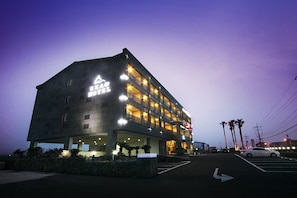 A multi-story hotel with a modern design, featuring a prominent sign and multiple balconies.