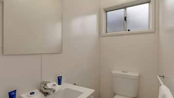 Un baño con inodoro, lavamanos y ventana.