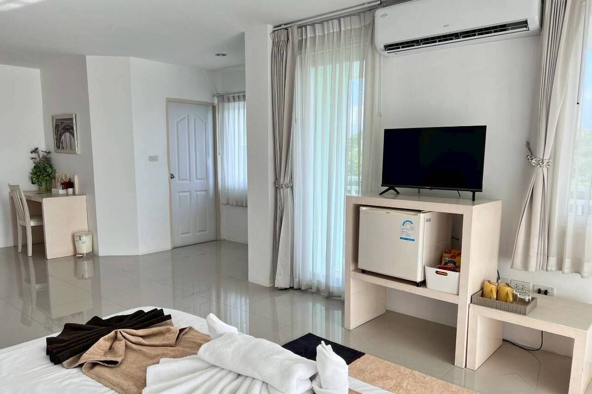 Une chambre d’hôtel moderne équipée d’un lit, d’une télévision, d’un minibar et d’un bureau.