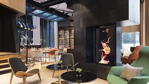 A modern interior with a glass ceiling, contemporary furniture, and a large digital art display. - Le Cinq Codet (Paris)