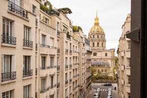 A view of a street with buildings, including a prominent golden-domed structure in the background.