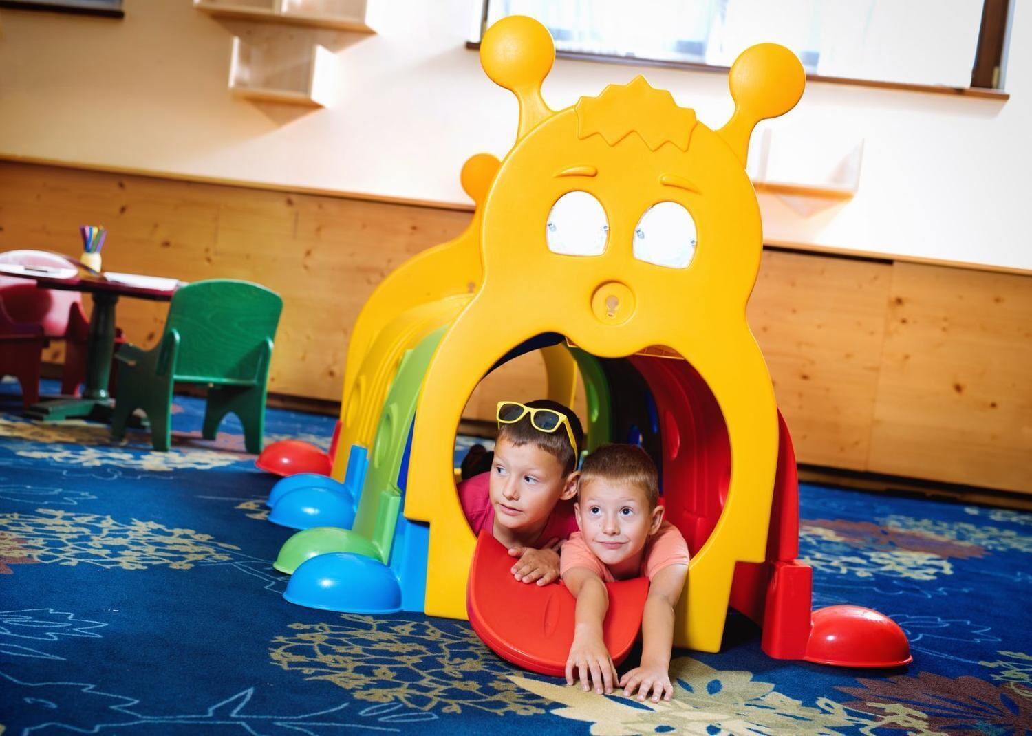 A play area with a yellow slide and colorful balls.