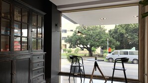 A modern interior with a large window, a wooden cabinet, and two chairs. - Talmud Hotel Taichung (Taichung)