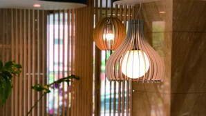 A modern lobby with a round glass table, a yellow armchair, and two hanging pendant lights. - Talmud Hotel Taichung (Taichung)