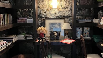 Un rincón acogedor para leer, con estanterías, chimenea y asientos cómodos.