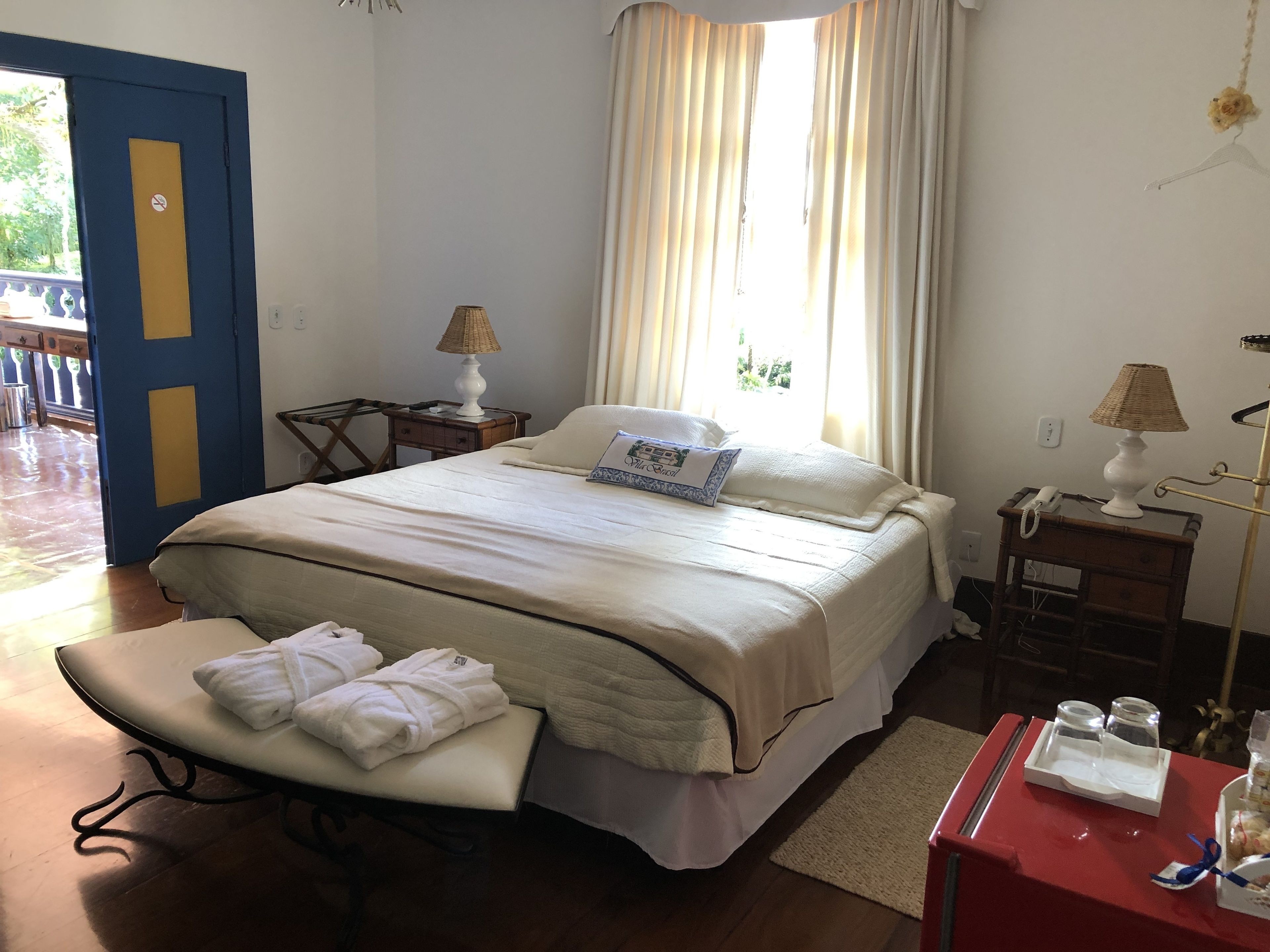 Une chambre d’hôtel comprenant un lit, des tables de chevet, un bureau, une chaise et une salle de bain.