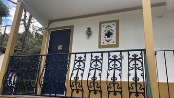 Un immeuble doté d’un balcon, d’une porte bleue portant le numéro 10 et d’une rampe en métal décorative.