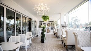 A modern interior with white furniture, patterned flooring, and a chandelier. - International Hotel Wagga Wagga (East Wagga Wagga)