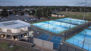 A sports complex with multiple tennis courts, a covered spectator area, and a parking lot. - International Hotel Wagga Wagga (East Wagga Wagga)