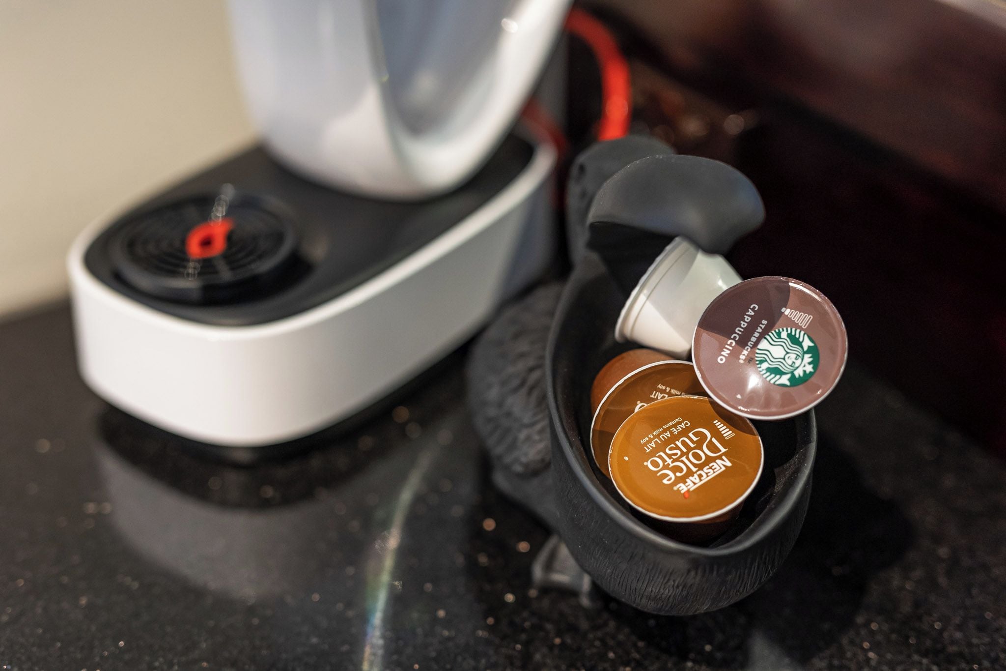 A coffee machine with two coffee pods, one labeled 'Cappuccino' and the other 'Dunkel.'