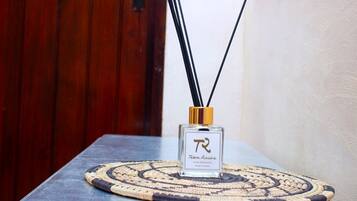 Una botella de Tabou Racis Home Fragrance sobre un posavasos tejido sobre una mesa.