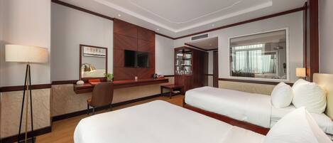 Habitación de hotel con cama, escritorio, silla, televisor y armario.