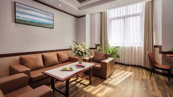 Una sala de estar moderna con un sofá, sillas, una mesa de centro y un cuadro en la pared.