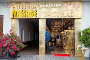 A massage spa entrance with a golden facade and a red carpet leading inside.