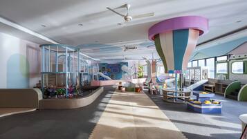 A play area with a slide, climbing structures, and a colorful hanging decoration.