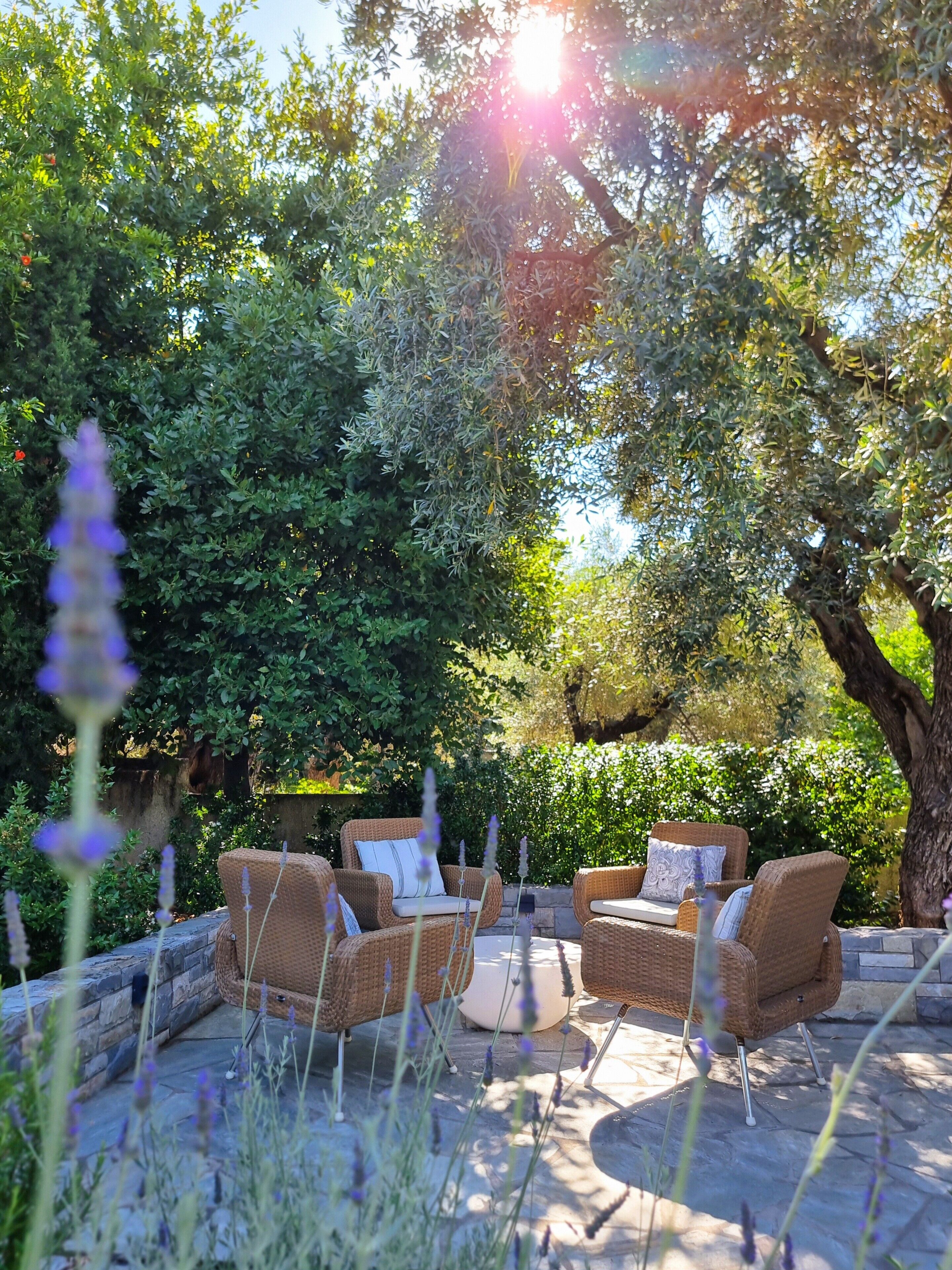 An outdoor seating area with wicker furniture and a stone floor.