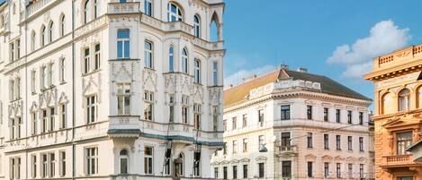 A historic building with ornate architecture, large windows, and a prominent corner tower.