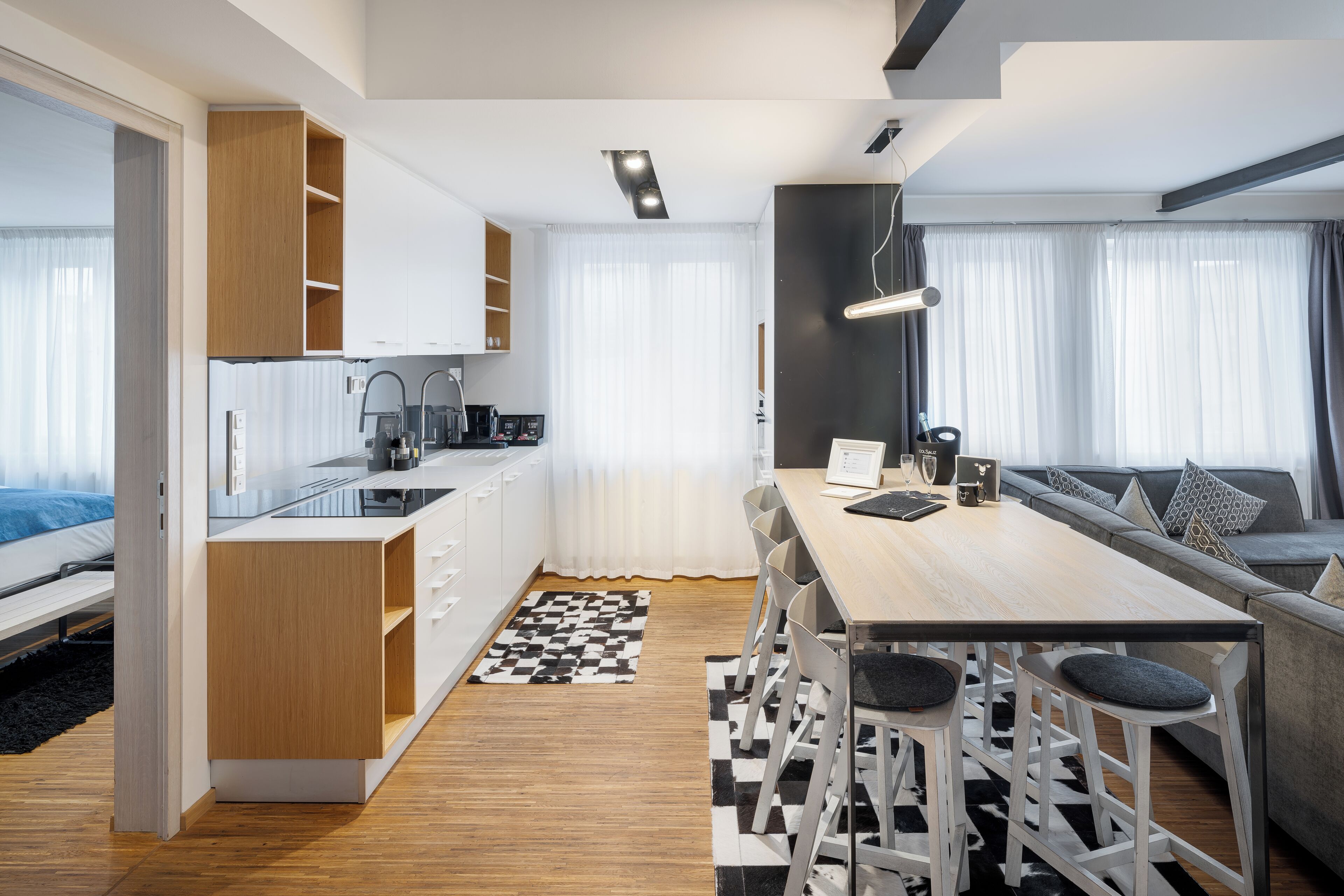 A modern apartment with a kitchen, dining area, and living room.
